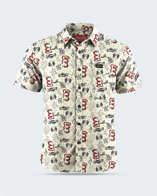 A short-sleeve button-up shirt with an all-over abstract pattern in red, black, and gray on a warm off-white background, shown against a light gray studio backdrop - Baja Button-Up Shirt by Greasy Hands Society