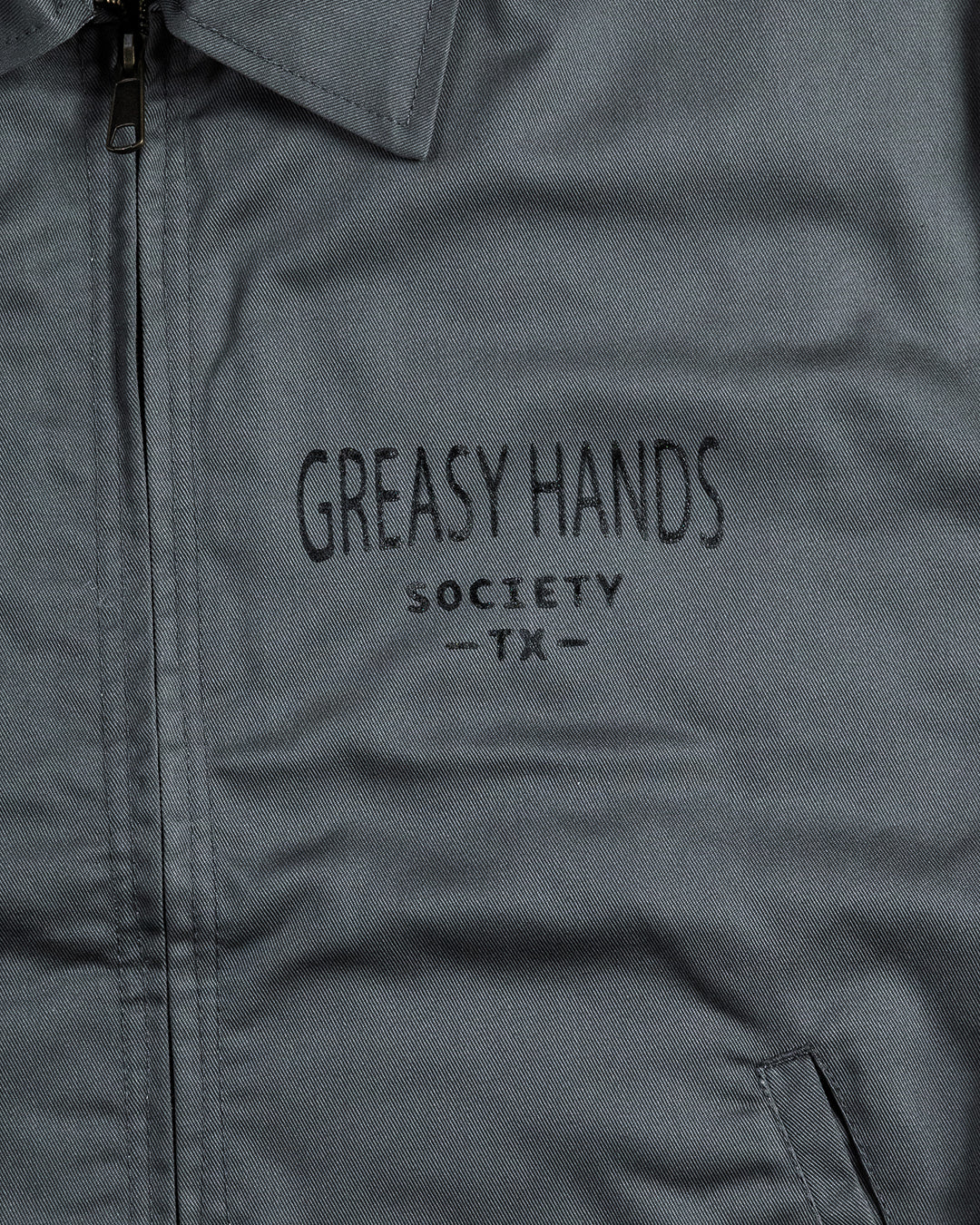 Gray mechanics jacket with 'Greasy Hands Society TX' text