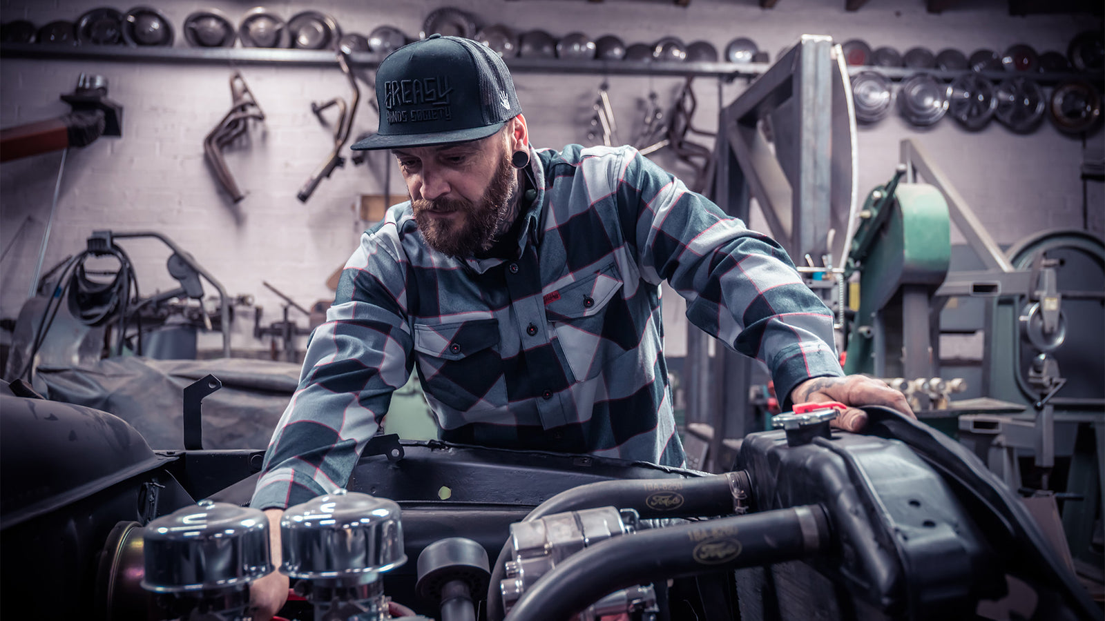 banger flannel being worn while a man works with his hands on an engine