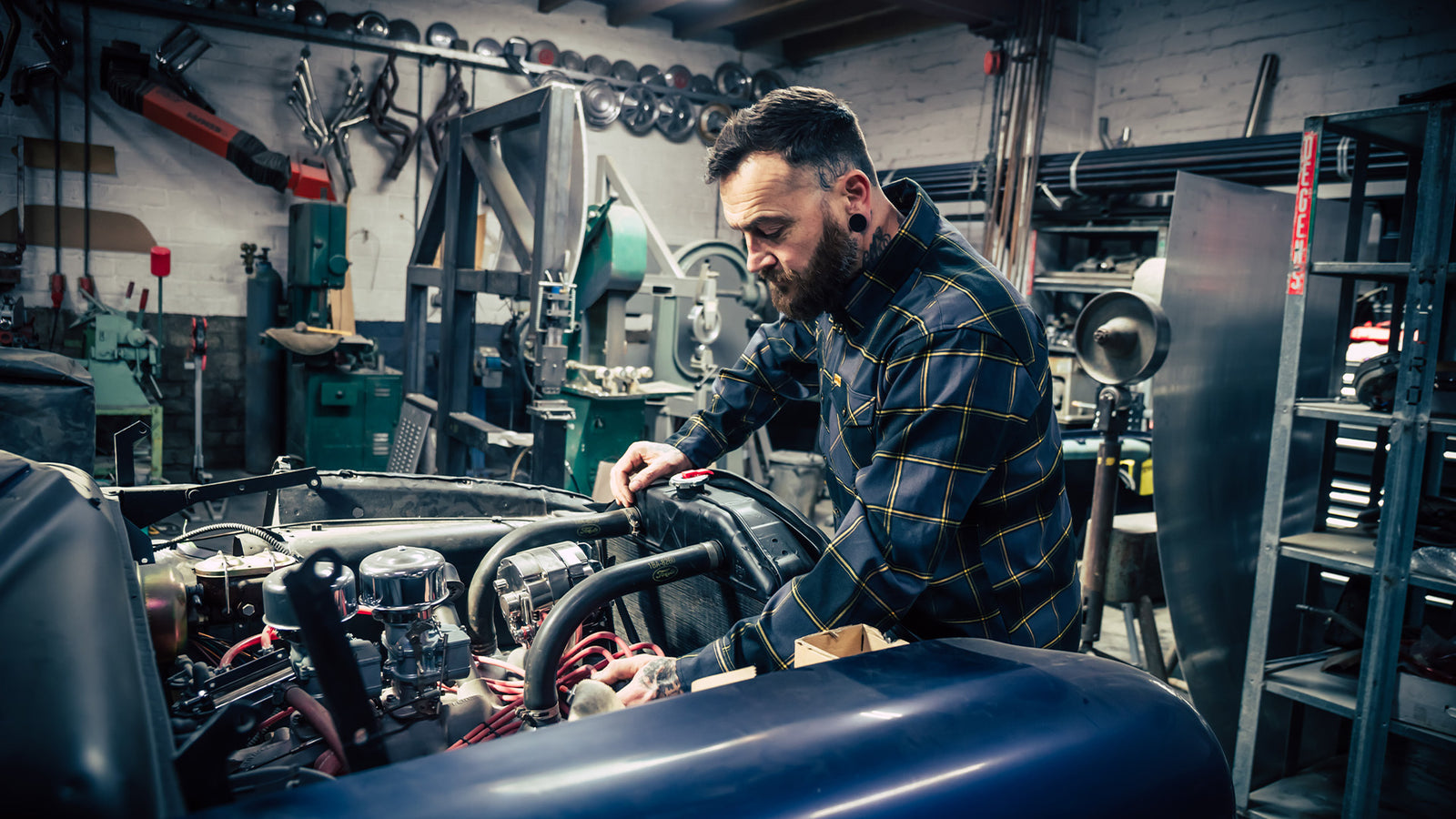 el lobo black grey and orange flannel worn by a guy working on a classic car