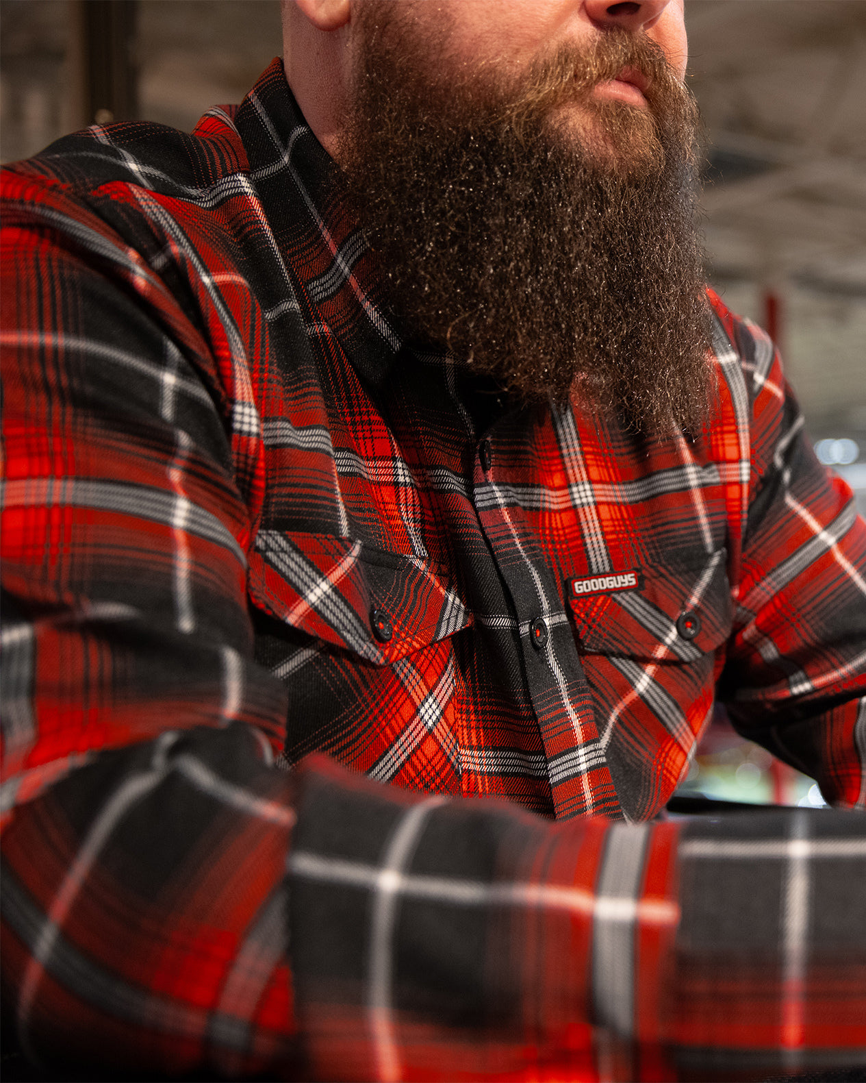 Man wearing a red and black plaid shirt called the detour flannel with a beard.