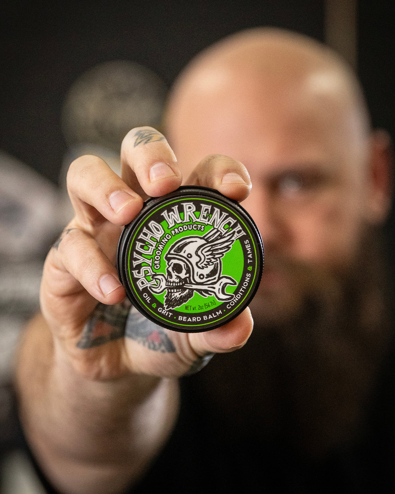 Man holding a can of psycho wrench grooming product 2oz beard balm