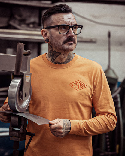 cross the line vintage orange long sleeved t-shirt with greasy in a diamond on the left chest