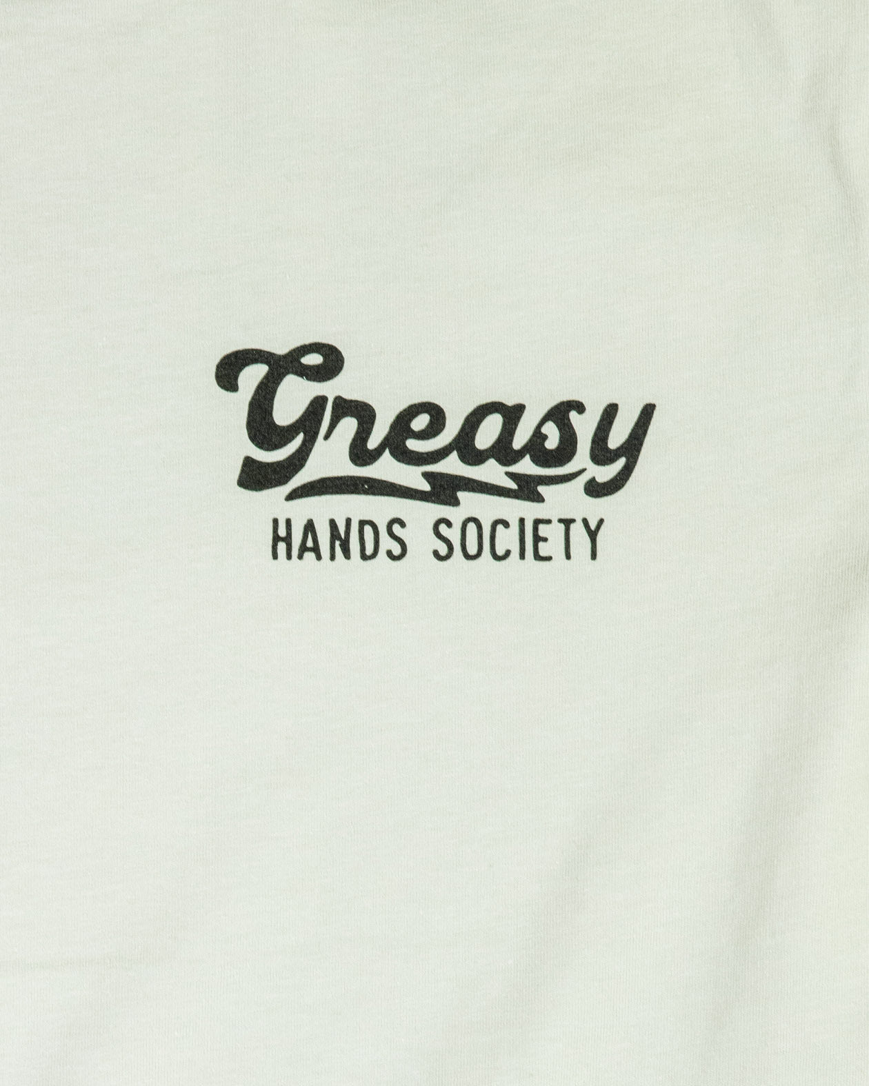 White sweatshirt with 'Greasy Hands Society' text on a white background - women's destination graphic tee detail of the front left chest graphic