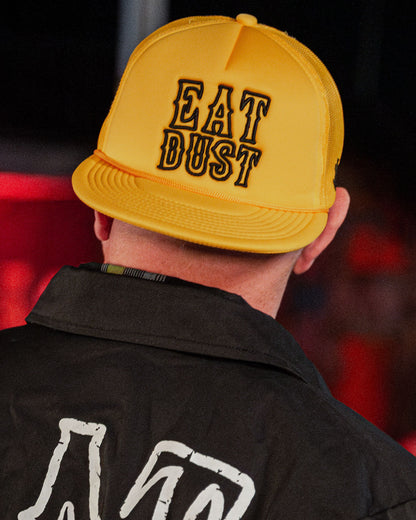 gold eat dust hat with black text