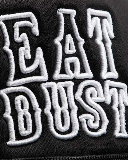 eat dust white text detail on black trucker hat