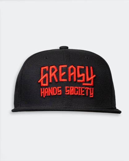 Black cap with red 'Greasy Hands Society' logo on a light gray background
