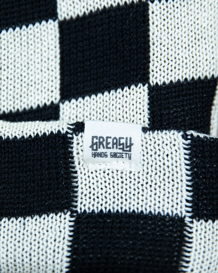 Black and white checkered beanie hat with a 'Greasy' label