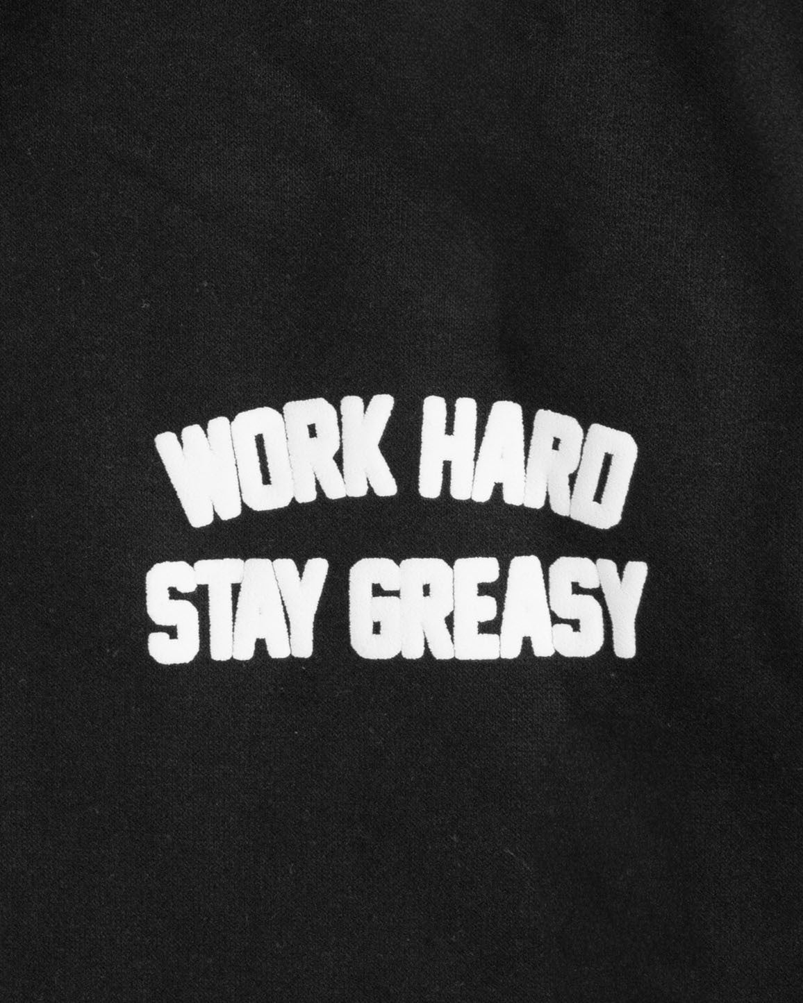 Black hoodie with 'Work Hard Stay Greasy' text in white on a black background