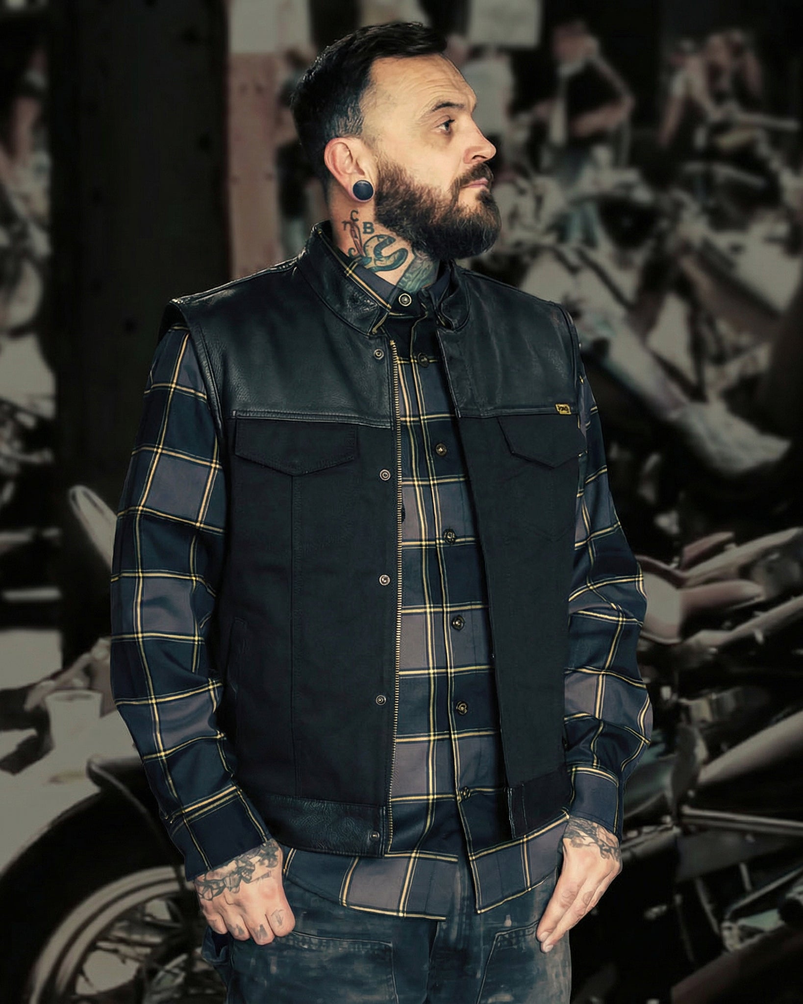 the jacinto leather and canvas vest worn open by a man in front of a rally print