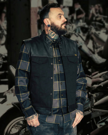 the jacinto leather and canvas vest worn open by a man in front of a rally print