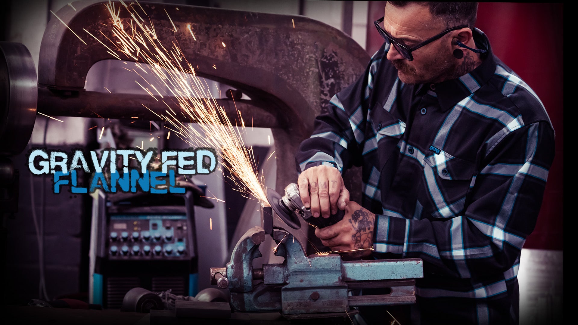 Person using a grinder with sparks, wearing a plaid flannel shirt, in a workshop setting. Gravity fed flannel for Canada